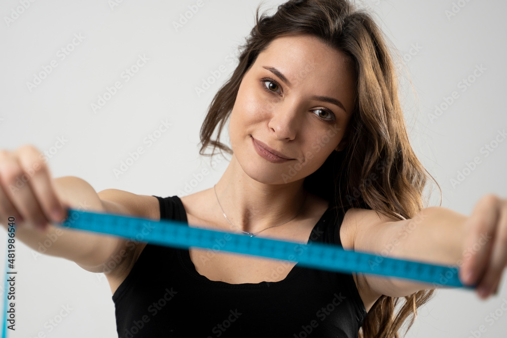 Attractive happy brunette female holding a measuring tape. Photo of young woman in underwear on white background. Weight loss concepts. Health care and healthy nutrition. Perfect slim body. Attractive happy brunette female holding a measuring tape. Photo of young woman in underwear on white background. Weight loss concepts. Health care and healthy nutrition. Perfect slim body.