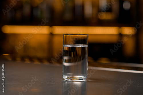 close-up glass of vodka on a bar counter in a blurred background