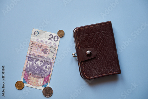 pieniądze, monety i brązowy portfel na niebieskim tle ,polski złoty 