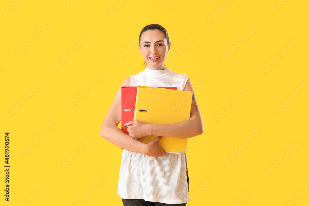 Beautiful young woman with folders on color background Beautiful young woman with folders on color background