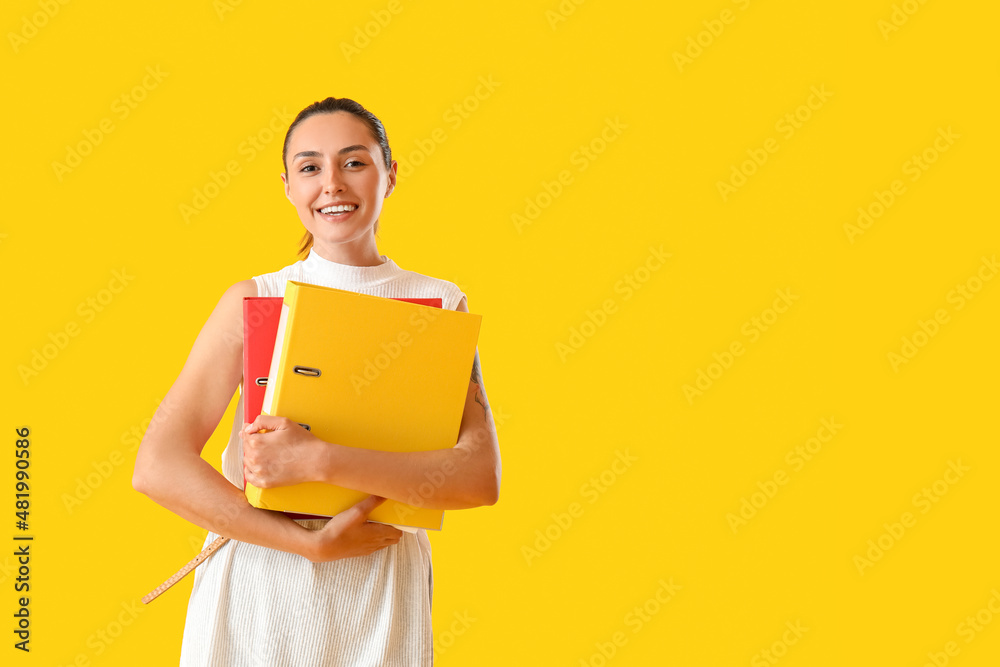 Beautiful young woman with folders on color background Beautiful young woman with folders on color background