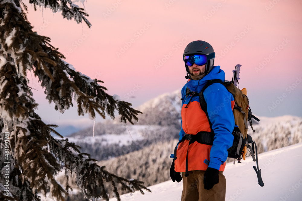 man ski suit and equipment with backpack against backdrop mountain. Freeride and ski touring concept