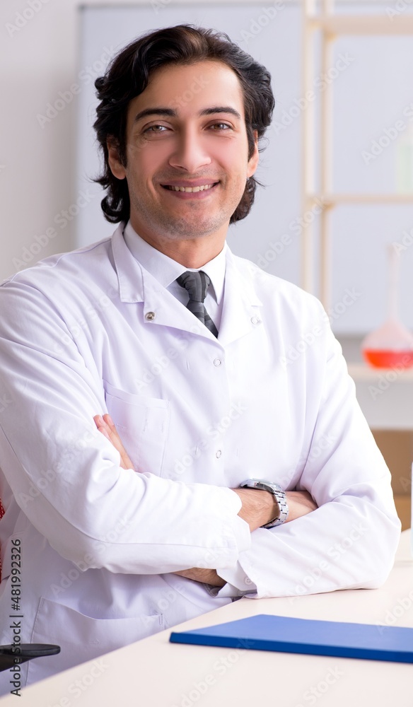The young handsome chemist working in the lab
