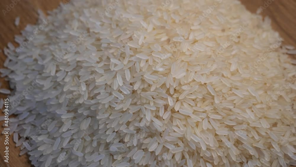 Grains of rice on a rotating wooden surface, top view.
Grains of rice on a rotating wooden surface, top view.