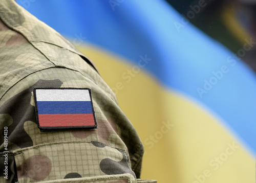 Flag of Russia on military uniform and flag of the Ukraine at background. Russia VS Ukraine. photo