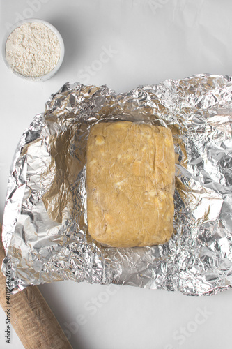 Rough puff pastry wrapped in cling film or saran wrap. Dough resting in cling film, morning buns dough photo