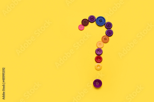 Question mark made of buttons on yellow background