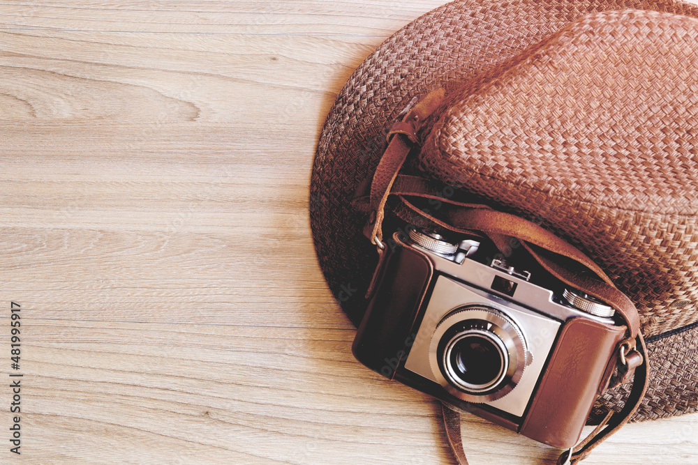 Vintage or Retro camera with brown hat on wooden background, retro effect style.