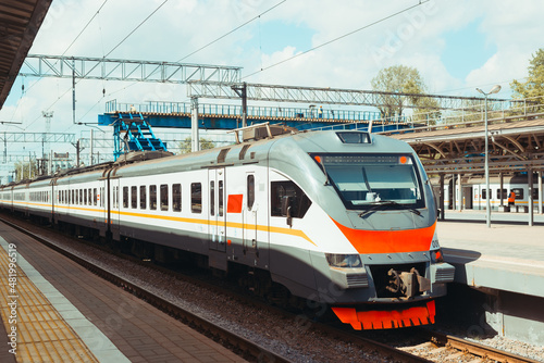 Modern high-speed electric train standing at railway station on summer sunny day, outdoors