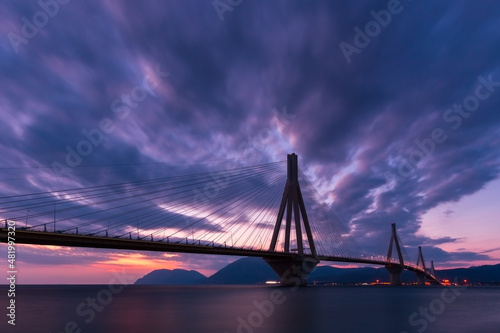 Huge suspension bridge with four large pillars over the sea strait at sunset, Rio-Antirrio, Peloponnese, Greece