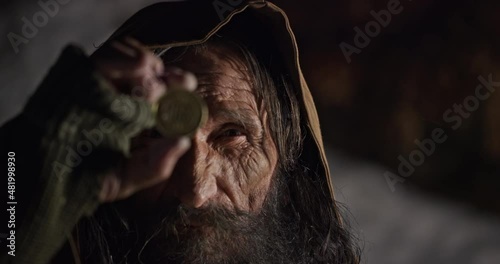 Wiseman examining golden bitcoin coin