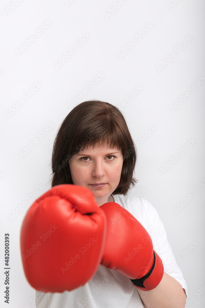 Portrait of young female boxer in red gloves on white background. Struggle for womens rights, feminism. Portrait of young female boxer in red gloves on white background. Struggle for womens rights, feminism.