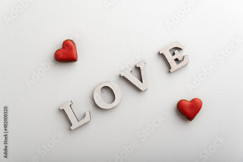 Word Love white letters and small red hearts. White background