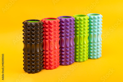 Foam massage rollers for myofascial release on yellow background. Therapy equipment. MFR. Front view