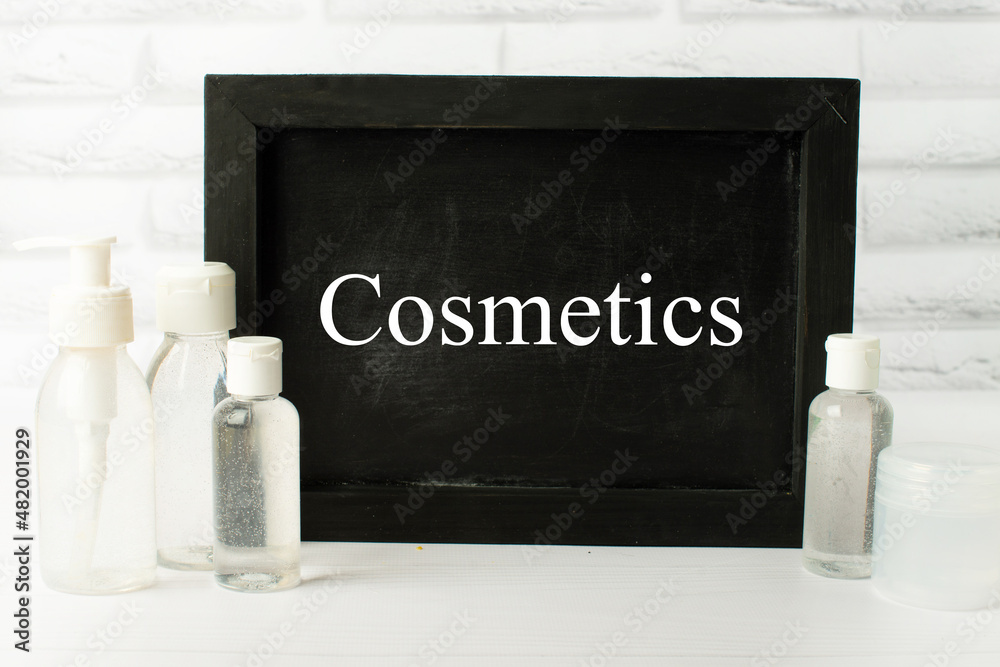 cosmetics text. Body care cosmetics on white background and slate board