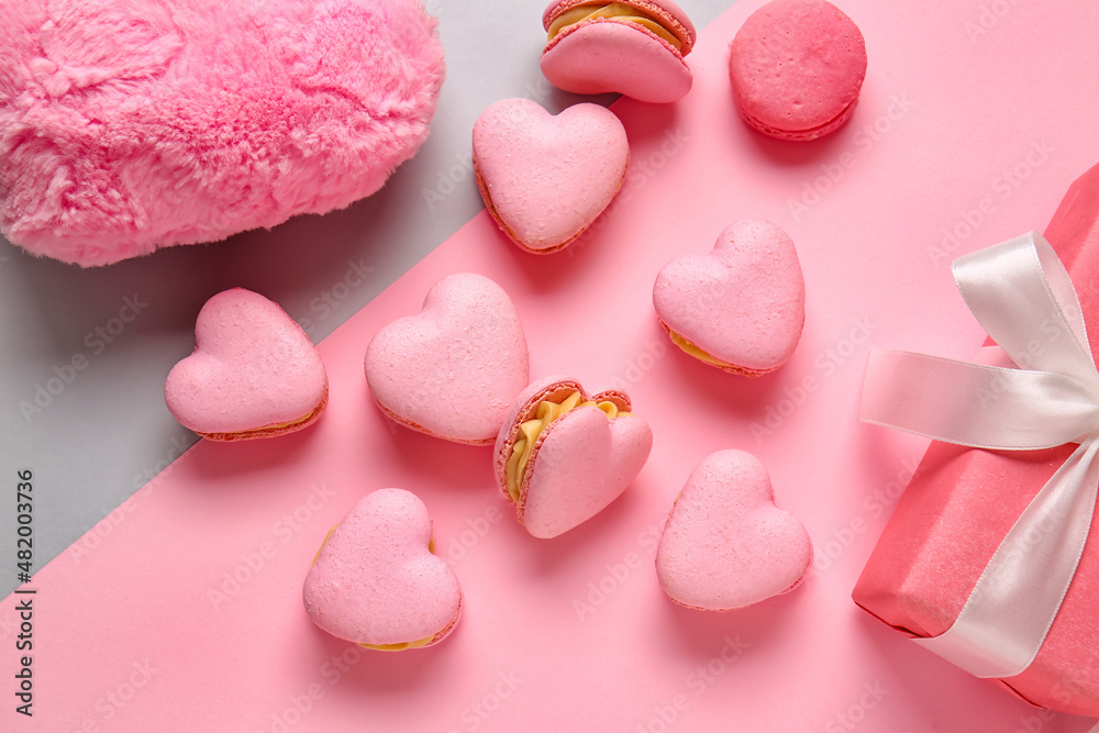 Tasty heart-shaped macaroons on color background