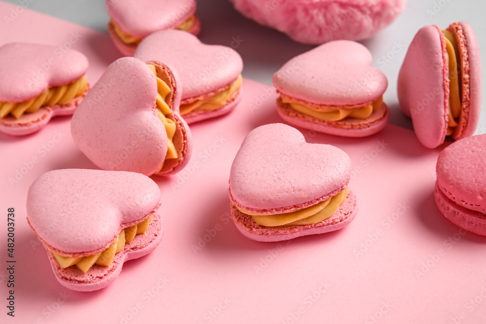 Tasty heart-shaped macaroons on color background, closeup Tasty heart-shaped macaroons on color background, closeup