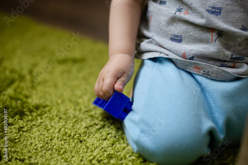 child toddler playing toys at home or nursery, Hand child playing with colorful construction blocks at home