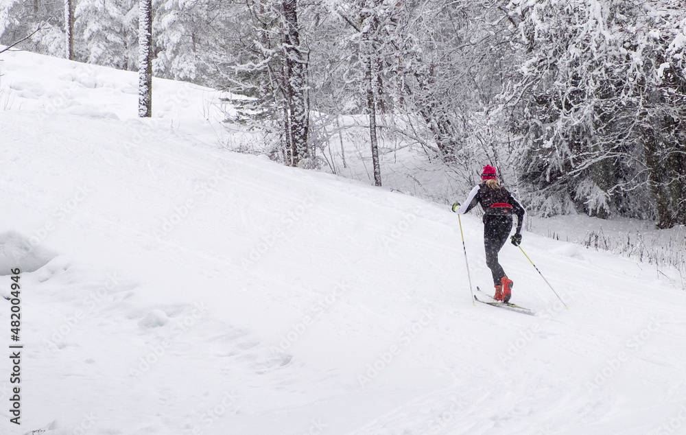 Girl athlete skier, runs on skis on the ski track. Winter sports.