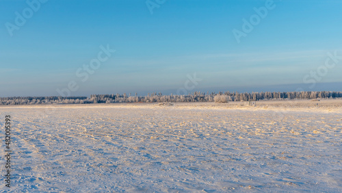 Winter farmland scenery landscape under snow with trees on background. Winter landscape with snow covered countryside.