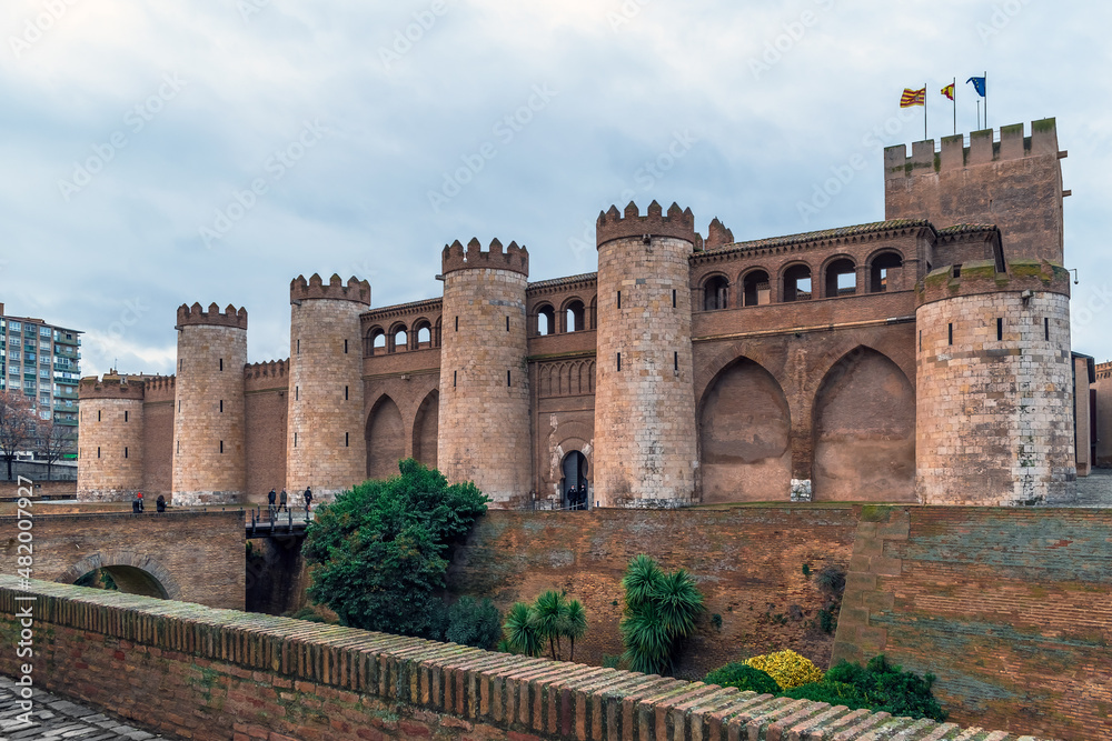 Saragossa, Spain - November 29, 2021: Exterior of the medieval stone fortress Aljaferia Palace in Zaragoza. Cityscape with ancient tourist attraction of spanish city