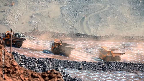 Three mining dump trucks ride through an iron ore quarry. Iron ore mining process. Visualization of modern technologies in the iron ore industry photo