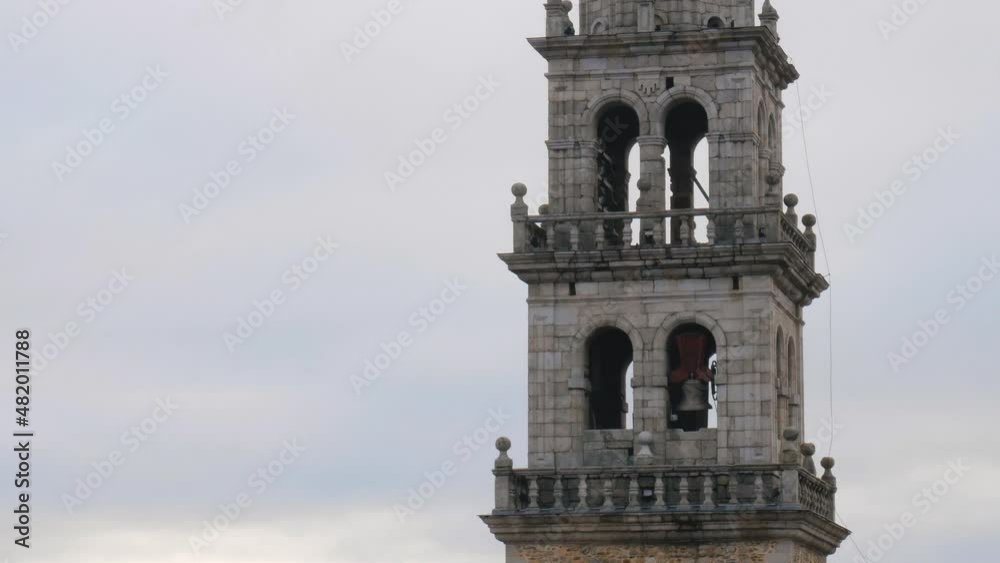 Close shot of The bells move and ring creating a sound that is heard throughout the region from the bell tower of the Basilica de la Encina, a Renaissance Christian temple in Ponferrada Close shot of The bells move and ring creating a sound that is heard throughout the region from the bell tower of the Basilica de la Encina, a Renaissance Christian temple in Ponferrada