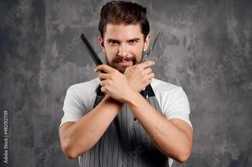 a man with a beard holds scissors and a comb in his hand hairdresser hair styling barbershop