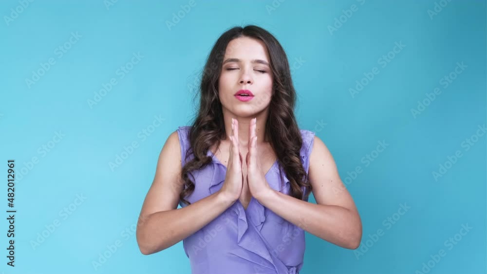Keep calm. Meditating woman. Meme expression. Pretty lady feeling tranquil holding namaste hands isolated blue looped video. Keep calm. Meditating woman. Meme expression. Pretty lady feeling tranquil holding namaste hands isolated blue looped video.