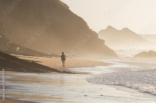 Woman walking on the Carreagem Beach. Aljezur. Algarve