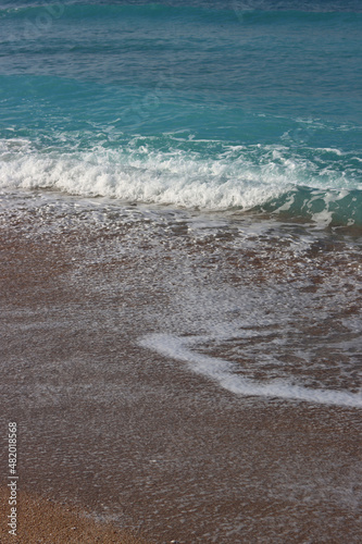 Clear blue sea water close up photo. Calm sea, blue sky, tranquil scene. Warm day on the beach. 