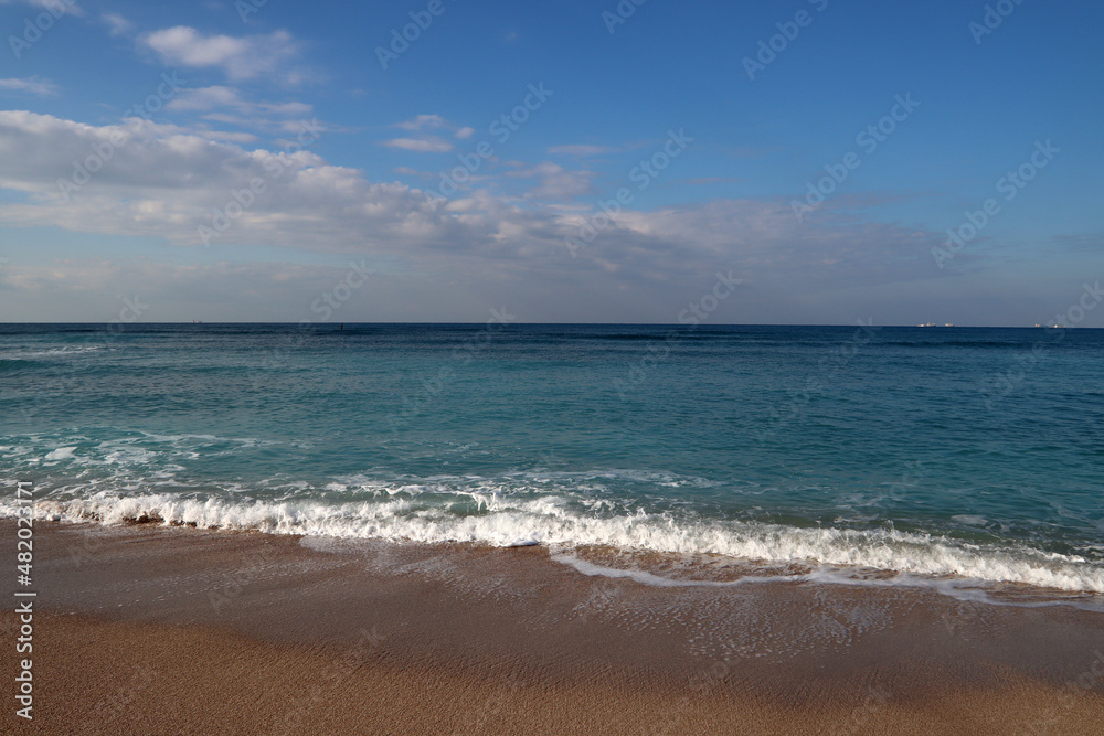 Beautiful seascape photo. Warm day in the beach. Calm blue water, clear sky, no people. 