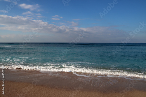 Beautiful seascape photo. Warm day in the beach. Calm blue water  clear sky  no people. 