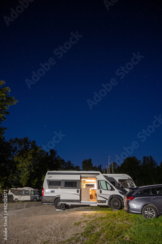 Campervan auf einem Wohnmobilparkplatz unterm Sternenhimmel