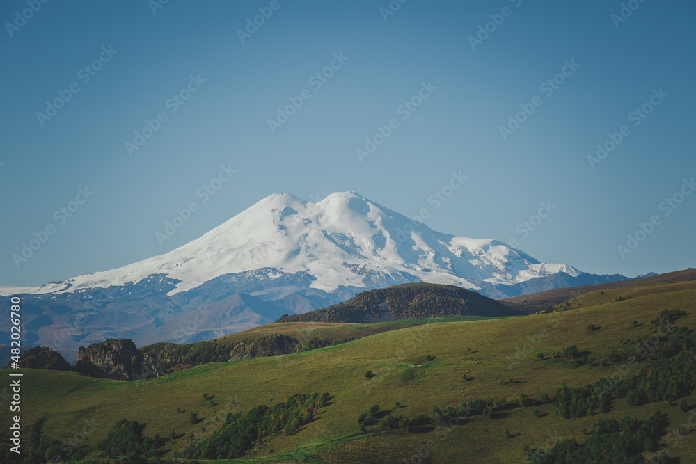 picturesque beautiful view of Elbrus, green fields and beautiful natural nature of the Caucasian mountains, the concept of travel in Russia.