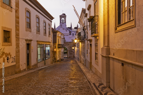 Arco da Vila at night, Monumental neoclassical archway leading to the old town, with remains of original Moorish wall of Faro, Algarve, Portugal