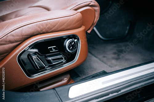 Premium car interior, brown perforated leather, decorative inserts the  interior, painted in orange wood color, leather steering wheel. photo