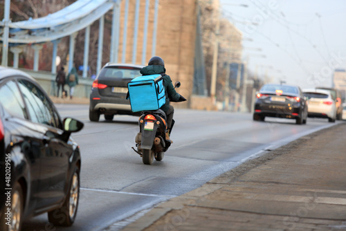 Kurier na motorze jedzie mostem Grunwaldzkim we Wrocławiu, dostarcza jedzenie. 