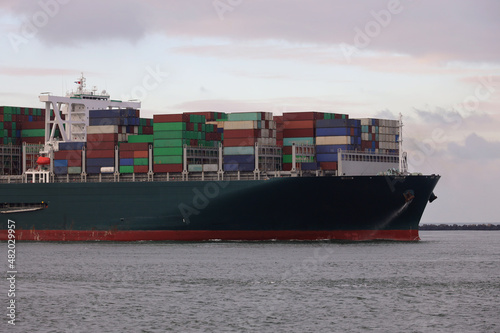 Grünes Containerschiff erreicht den Hafen