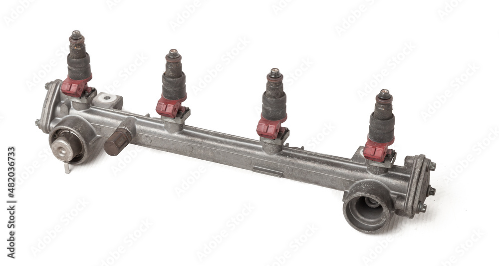 Close-up on a car fuel rail with injectors for supplying gasoline to a four cylinder engine on a white isolated background. Spare parts catalog
