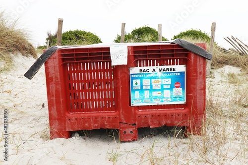 Tide tray on a beach on the sand in France.Plastic tray to put waste on the beach (France - 21/01/2022) photo