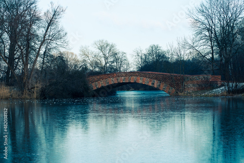 Mostek ceglany rzymski nad stawem zimą
