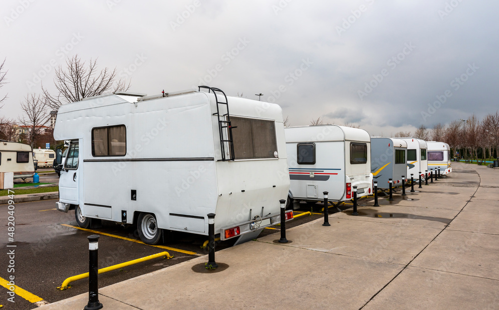 Motorhomes parked at motorhome campground. Caravan parking. Camper Trailers parking area.