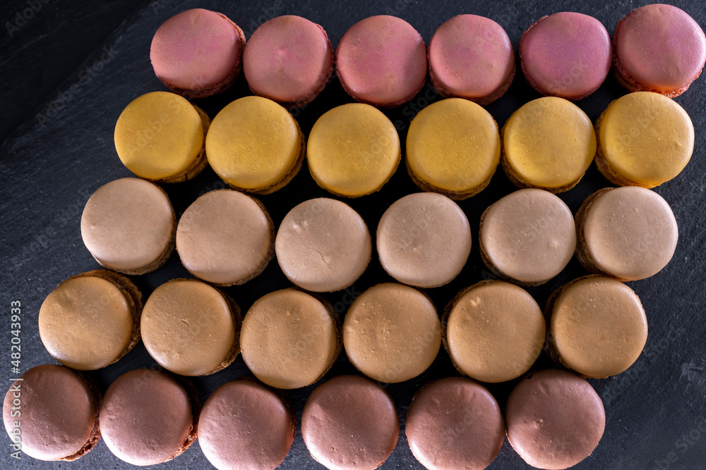 chocolate, coffee, vanilla, lemon and strawberry macaroons on black background chocolate, coffee, vanilla, lemon and strawberry macaroons on black background