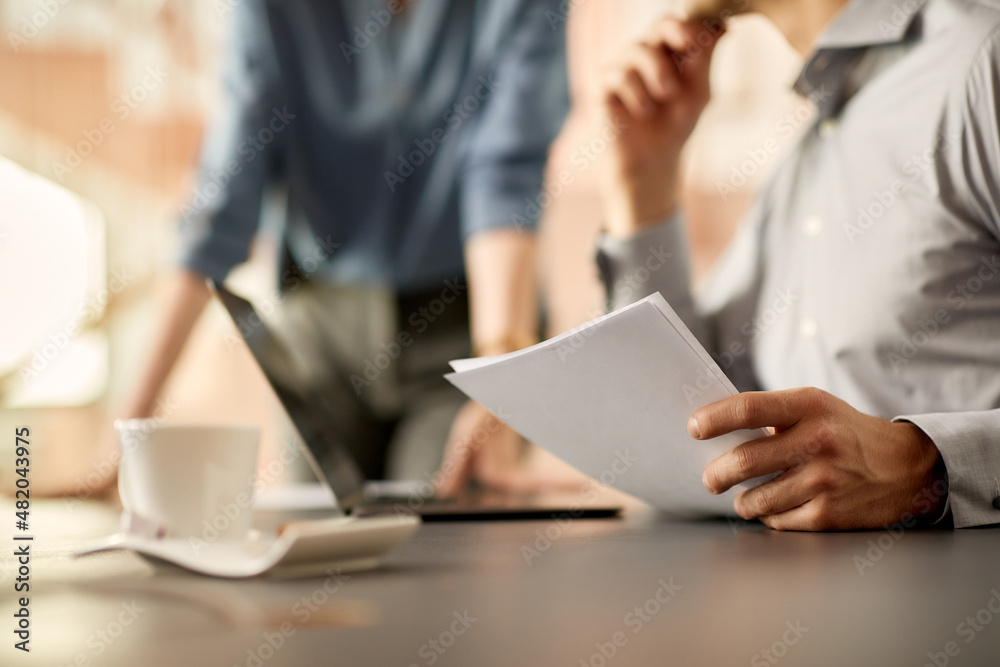 Close-up of businessman analyses reports with colleague in the office. Close-up of businessman analyses reports with colleague in the office.