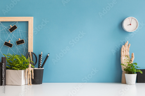 Home office desk with blue wall and white table mock up.	 photo