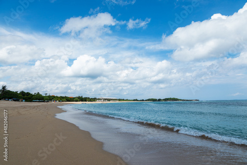 Tropical landscape. High waves with foam spread on the coast. Nusa dua beach, Bali island, Indonesia. Beautiful summertime view ocean on the white sand beach. © Vitalii_Mamchuk