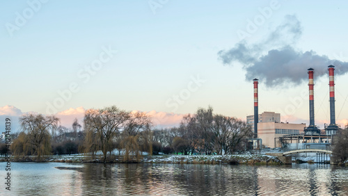 Smoking chimneys of a thermal power plant against a winter cloudy sky. Ecological problems concept. Space for text.
