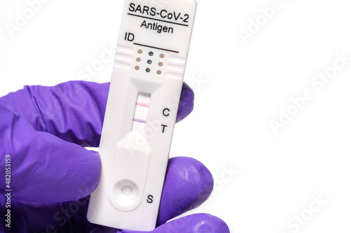 hand holding COVID-19 rapid antigen test positive result, immunochromatography of antibodies to detect infections photo