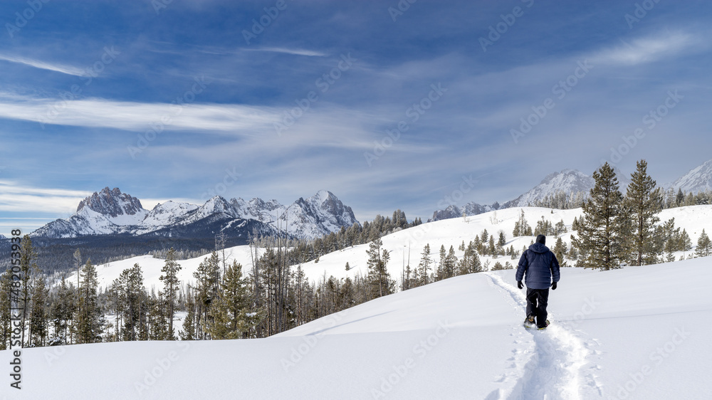Man snowshoes into the Idaho wilderness in winter snow